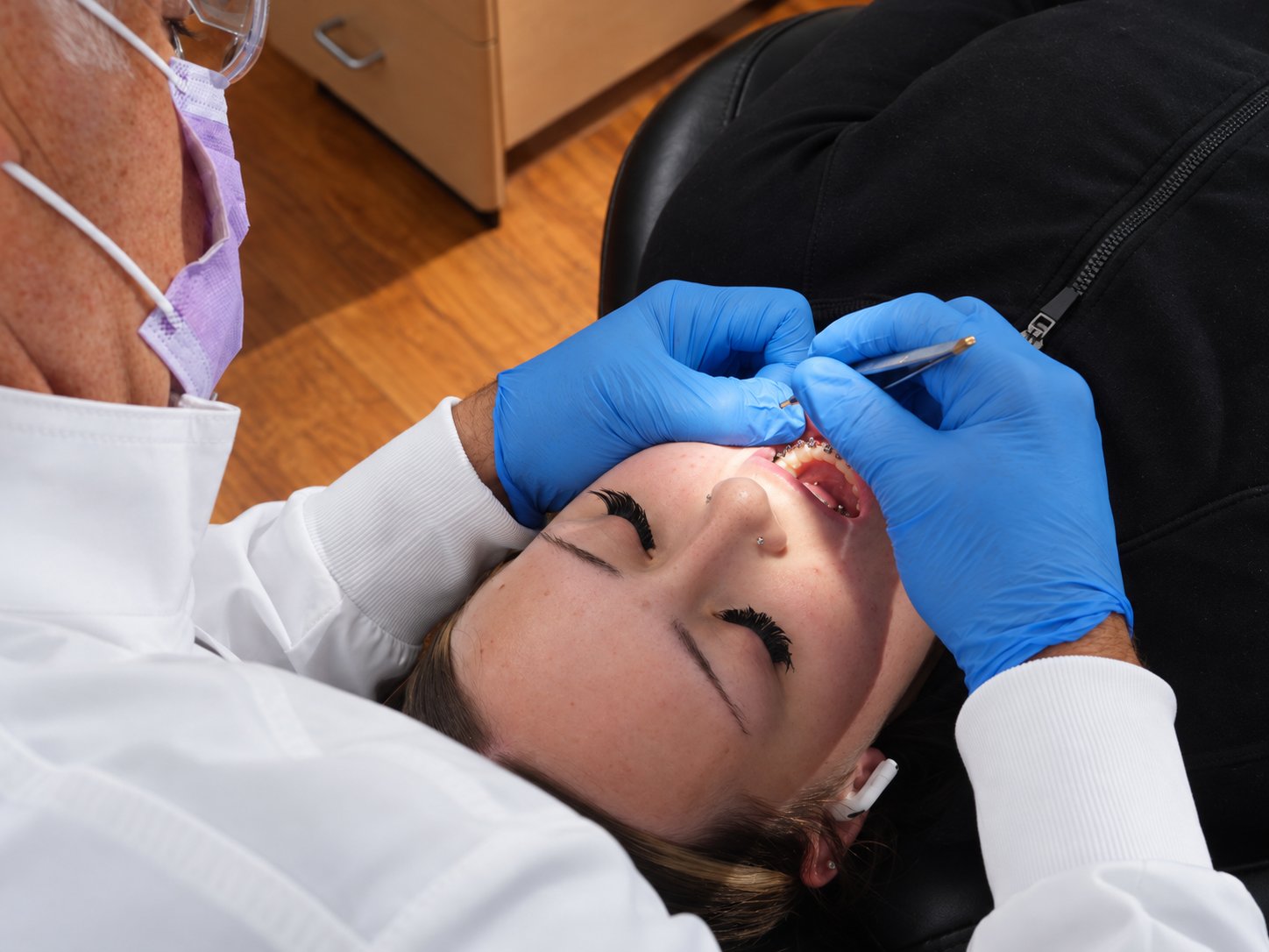 Orthodontist caring for an adult patient in the treatment chair